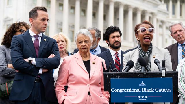 Rep. Yvette Clarke speaks at a podium with a "Congressional Black Caucus" poster on it in front of the U.S. Capitol.