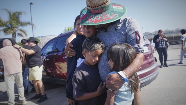 People embrace outside of Glass House Farms, a day after an immigration raid on the facility, on Friday, July 11, 2025, in Camarillo, Calif. (AP Photo/Damian Dovarganes)