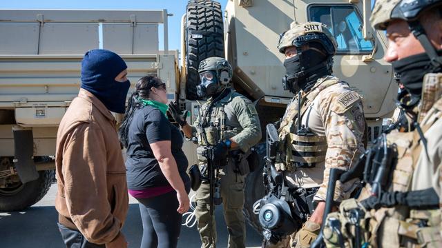 Federal immigration agents talk to Rebecca Torres, second left, after she tried to block a military vehicle during a raid in the agriculture area of Camarillo, Calif., Thursday, July 10, 2025. (AP Photo/Michael Owen Baker) Federal immigration agents talk to Rebecca Torres, second left, after she tried to block a military vehicle during a raid in the agriculture area of Camarillo, Calif., Thursday, July 10, 2025. (AP Photo/Michael Owen Baker)