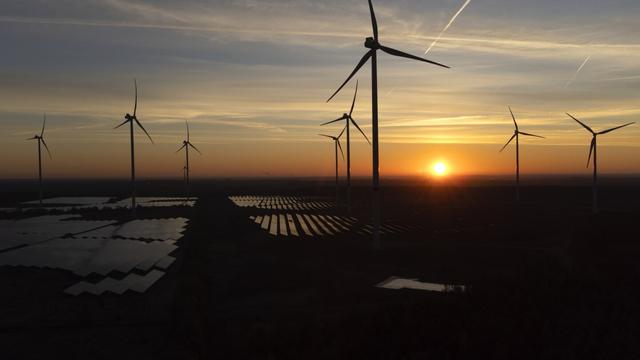 Wind turbines operate as the sun rises at the Klettwitz Nord solar energy park near Klettwitz, Germany, Oct. 16, 2024. (AP Photo/Matthias Schrader, File)