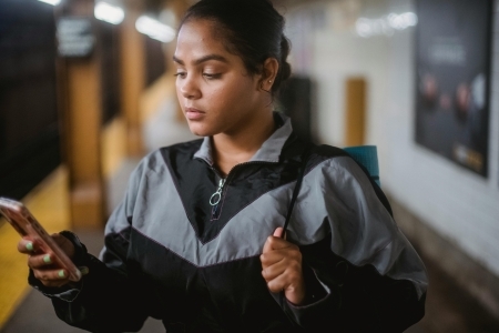 A woman looking at earned media on a phone.