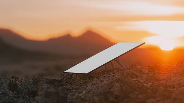 A rectangular satellite dish sitting on the ground outdoors.