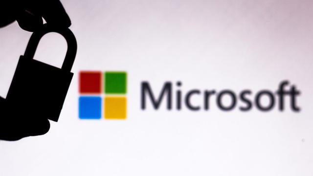 In this photo illustration a padlock appears next to the Microsoft Corporation logo