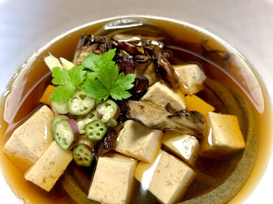 In a clear soup made from soy, mirin and kombu stock is the green katuk soba noodles, browned maitake mushrooms, mitsuba leaves, pink okra and tofu squares. 