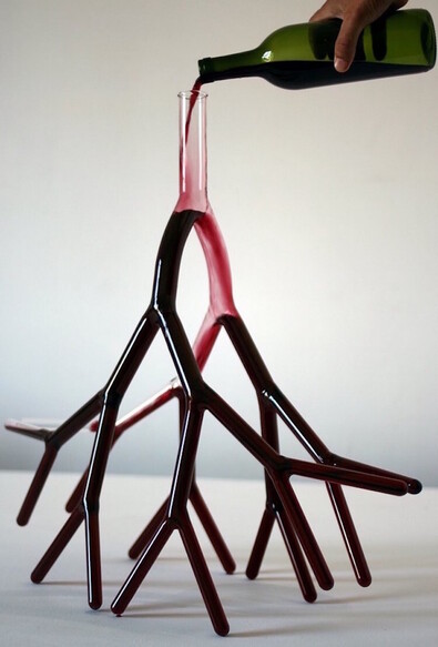A decanter that looks like blood vessels being filled with red wine. 