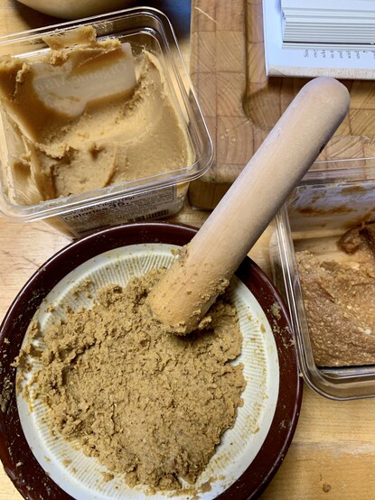 Image shows the combination of the two miso pastes into the suribachi bowl so that it closely resembles the acorn's colour. 2 1/2 Tablespoons white miso, 1 1/2 Tablespoons red miso, 1/4 cup leached willow oak acorns. 