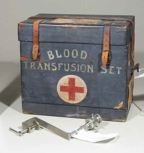 A blue-grey box with a Red Cross on it, which reads: "BLOOD TRANSFUSION SET." 