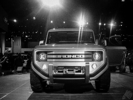 A black and white photo of a 2004 Ford Bronco concept at the New York International Auto Show.

Javits Center, NYC (2004)

*

Inspired by the first-generation (1966â€“1977) Ford Bronco, the 2004 concept adapted a short wheelbase, round headlamps, and squared-off roofline; the concept marked one of the first uses of a three-bar grille on Ford vehicles. Using a minimalist exterior design, the Bronco design was unveiled alongside a Shelby Cobra Concept at the same show.
