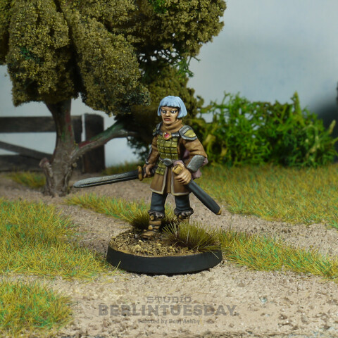 Wargame figure. Female fantasy warrior with pale blue bobbed hair. She wears green plate Armor a light brown jerkin and grey trousers. She carries a sword. 