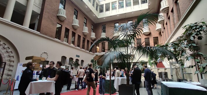 Inner yard of an old early 1900s beautiful building, buzzing with people chatting with each other.