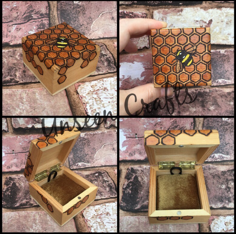 Small wooden box with bee and honeycomb on lid and down sides.