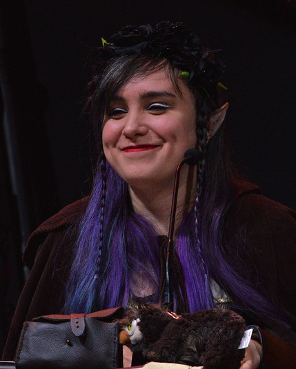 A photo of Ellen Rose as Merilwen the Wood-Elf Druid. She is smiling and looking toward the crowd.