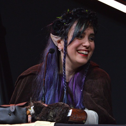 A photo of Ellen Rose as Merilwen the Wood-Elf Druid. She is smiling and looking to her side.