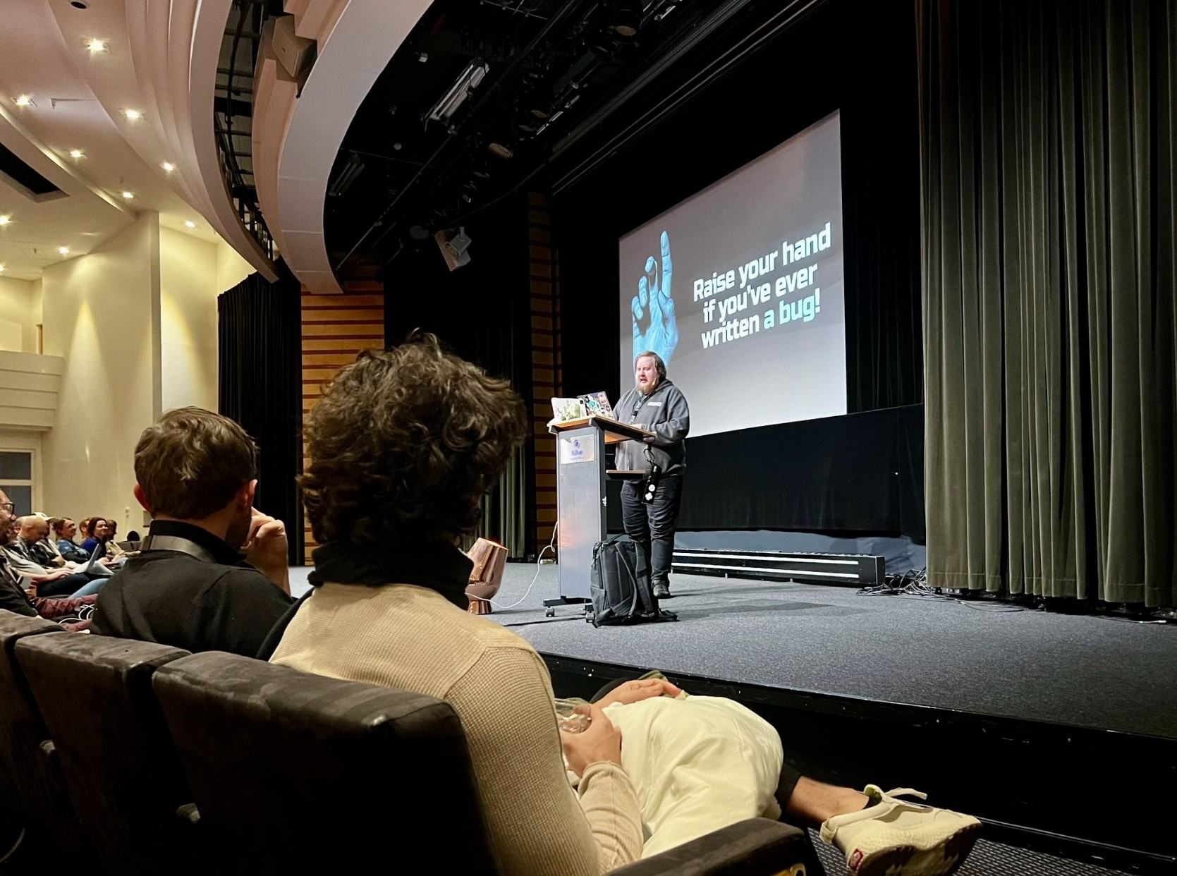 Juhis talking on a stage with a slide that reads 