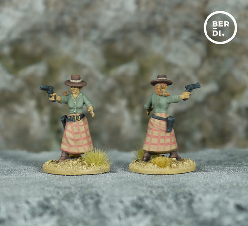 wargame model. Female gunslinger. She wears a mid-brown hat, soft green shirt and a tan and muted-red check dress. She carries a six-shooter gun.