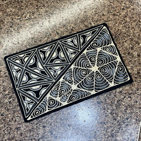 A piece of line art done using the Zentangle practice. A black rectangular paper art tile divided along the diagonal into 2 large triangles. Each triangle is filled with smaller triangles that are filled with new patterns of circles and spirals. All the line art is done with gold metallic ink. There is white pastel chalk used for highlights, and some graphite added for texture.
