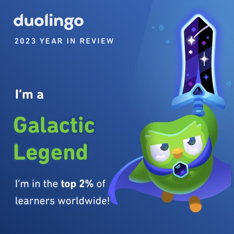 An image of duolingo, the green owl holding up a broad sword whose blade looks like a starry night. It is also wearing a blue cape with a purple brooch in front. 

To the left it says “duolingo 2023 year in review” 
“I’m a galactic legend” 
“I’m in the top 2% of learners worldwide.”

The background of the image is blue. The font is white but “Galactic Legend” is in green like the owl. 