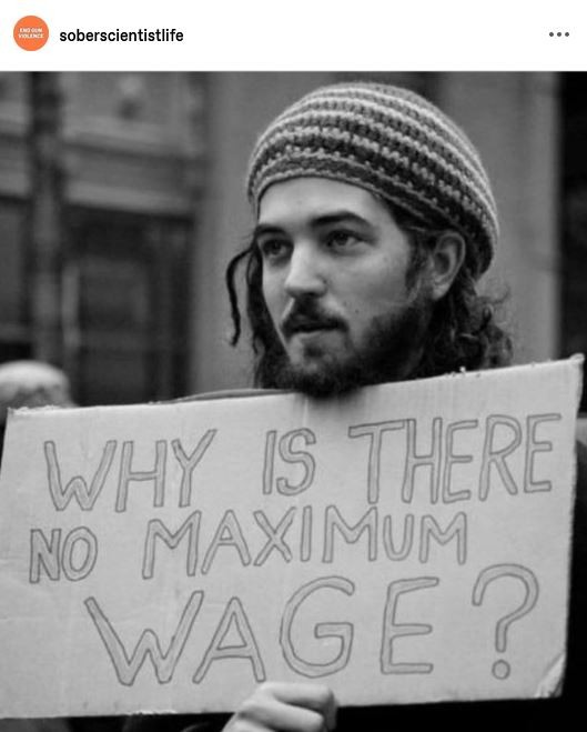 Post by soberscientistlife: A photo of a demonstrator holding a sign that reads, "Why is there no maximum Wage?"
