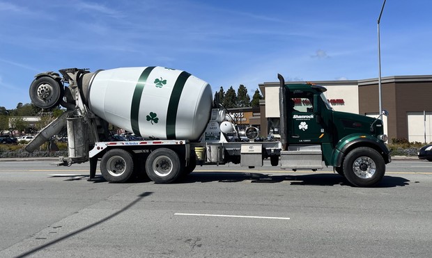 A cement truck with shamrocks on the drum