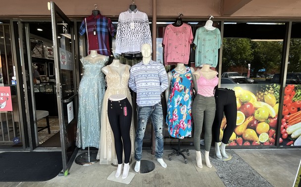 A family of mannequins outside a boutique. Several are headless and none is chic.