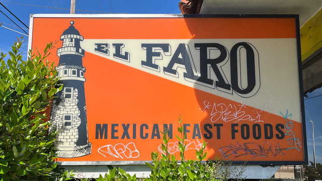 Restaurant sign with a lighthouse on the lift and EL FARO contained in the beam. The beam is horizontal on the upper edge and slanted down on the lower edge, with the letters stretched to meet each edge. The "A" has a slanted middle stroke while the E, the F, and the R each have a horizontal middle stroke. 