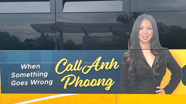 Ad on the side of a bus--
When Something Goes Wrong, Call Any Phoong--featuring a photo of Anh Phoon, hand on hip, looking right at you.  