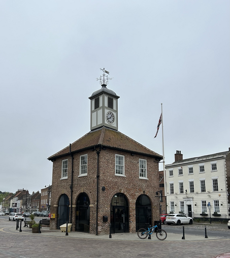 A picture of Yarm Town Hall, a square brick building with a clock tower and a weather vane on top.