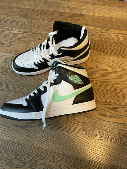 Black and white Jordan 1 sneakers with mint green details