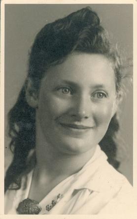 Vintage black-and-white portrait of a smiling woman with styled hair.