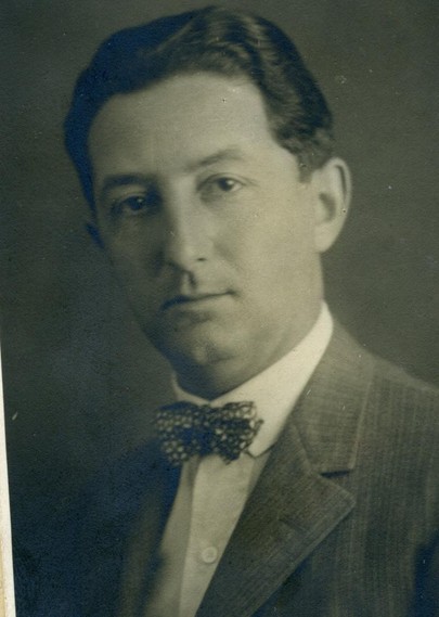 Vintage black and white portrait of a man wearing a bow tie and suit.