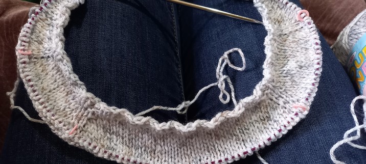 Photo shows a baby cardigan in progress, the Tin Can Knits simple cardigan in King Cole Cloud Nine dk in shade Morning Dew, which is a kind of stone/brown/warm cream colour which will suit my colleague's favoured colourways.