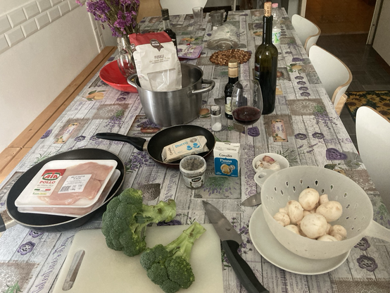 Ingredients out for cooking-chicken breasts, broccoli, mushrooms, capers, panna (cream, in a shelf-stable carton), garlic, wine, olive oil, pasta
