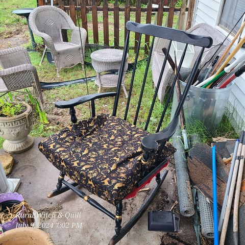 An old rocker with a new seat cushion of cats, worlds, crows, and other magical items.