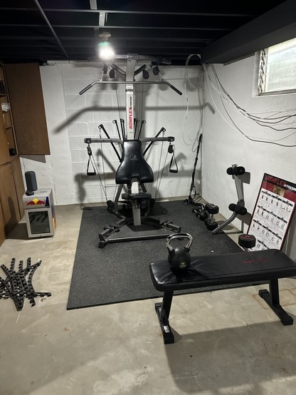 The bowflex set up in a corner of my basement. Other various free weights can be seen lying about. 