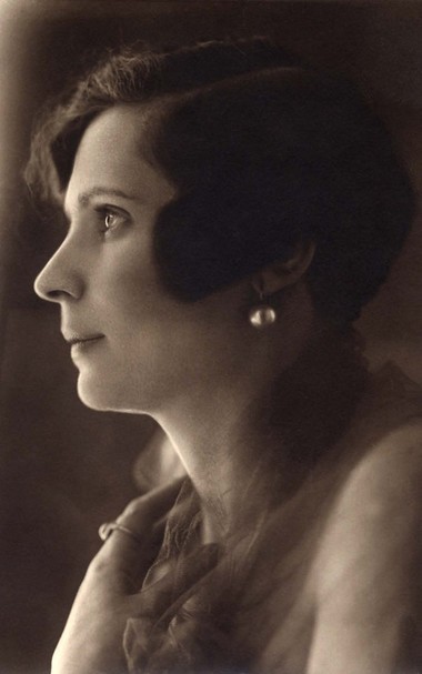 Vintage portrait of a woman with an elegant profile, wearing pearl earrings and an off-shoulder dress
