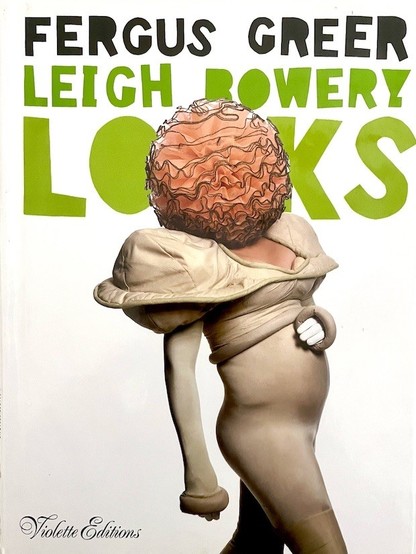 A book entitled 'Leigh Bowery: Looks', by Fergus Greer. The author-photographer Fergus Greer took photographs of the creative, outlandish fashions by Australian performance artist Leigh Bowery. The cover shows Bowery in partial profile, encased in a form-fitting cream colored sheath-type garment with exaggerated shoulders. His head is hidden inside a giant bubble of wavy orange tulle. Titles are in black & green on a white background.