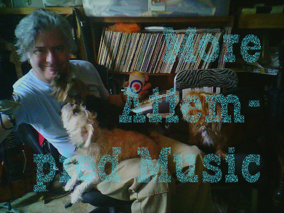 My three small dogs overwhelming me as I recline in my studio/den/office, a beer in my hand, smiling at the camera in my t-shirt and khakis, having finished recording yet another cover song, behind the usual words, 