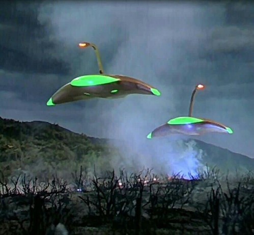 A still from the 50s film version of “War of the Worlds” shows Martian invader spaceships gliding over a desolate Earth landscape.