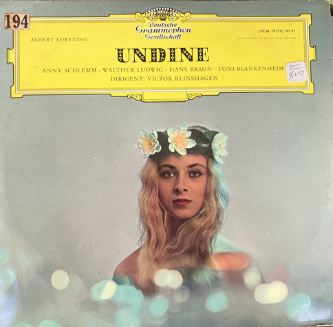 The cover of an LP record of Lortzing’s Undine, showing a the face of a very blond young woman crowned with white and yellow flowers, with blurrily lit foreground to suggest the surface of the stream