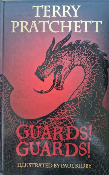 Cover of 'Guards! Guards!' by Terry Pratchett. It's red with a huge dragon with her mouth open in black and red.