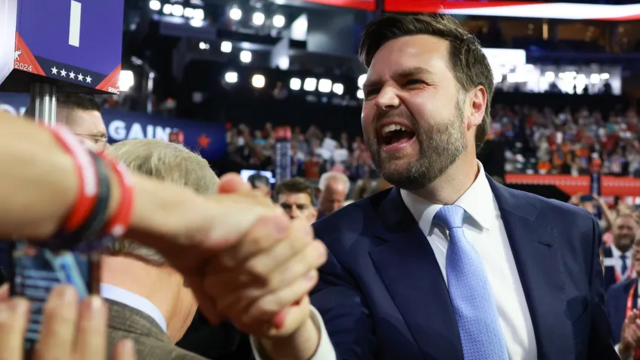A very happy J. D. Vance reaching out to shake a woman's hand at the Republican National Convention