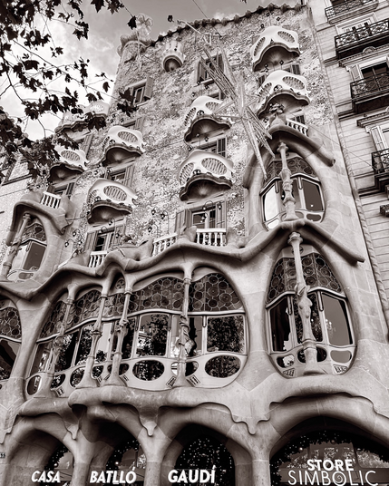Black and white photo of Casa Batlló building in the center of Barcelona, Spain. It was designed by Antoni Gaudi. The local name for the building is Casa dels ossos (House of Bones), as it has a visceral, skeletal organic quality.