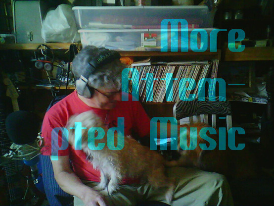 Me in a red hat with headphones and glasses, from above, in a dark, cluttered room, next to two dogs on two chairs to my left.
Banner text says 