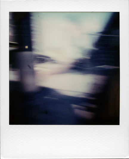 A failed attempt at candid street photography using a Polaroid Go camera, resulting in a completely blurred and abstract shot.