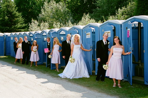 Married couples emerge from a row of little chapels that happen to look exactly like portable latrines.