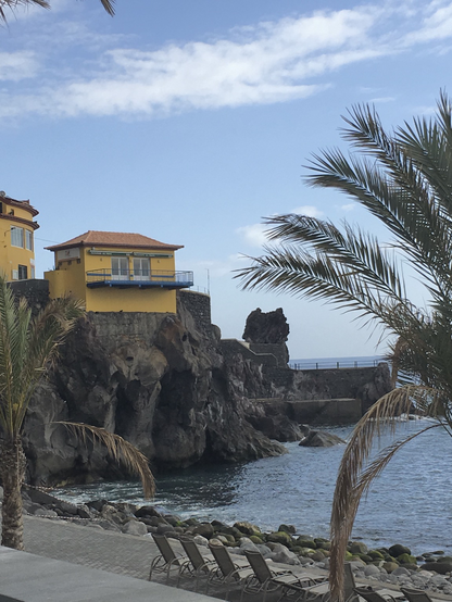 Mustard yellow house on a small cliff by the sea