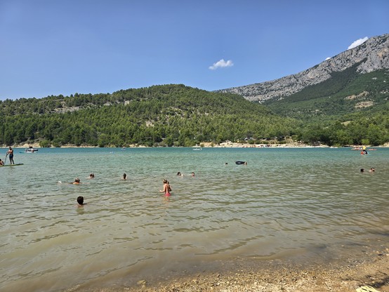 Lac de Sainte-Croix under a blue sky with people swimming