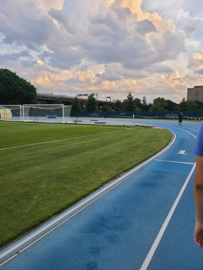 The start of the 200m on the track. Lane 1 is shown with the inner grass. The sunset is tinting the clouds gray and gold