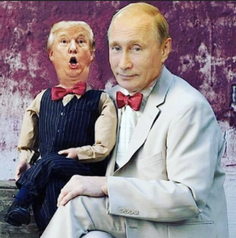 trump the puppet boy w/ big gaping mouth, sits on Putin’s lap, while Putin gazes into the picture, smiling.
