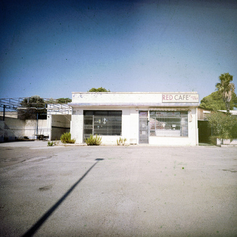Photo of an old leftover café found somewhere along the road, the sign says RED CAFÉ in capital letters but there is no red in the photo whatsoever. Shot on 120 expired Kodak Ektachrome 100 PLUS EPP analog film with a Lomo Lc-a 120 camera.